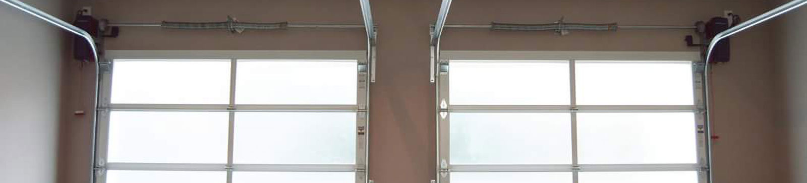 Completed double electric glass garage doors with aluminum frames in Coon Rapids garage