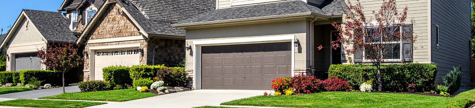 Row of suburban homes with freshly maintained garage doors in Coon Rapids, MN, representing reliable service by Garage Door Repair Coon Rapids.